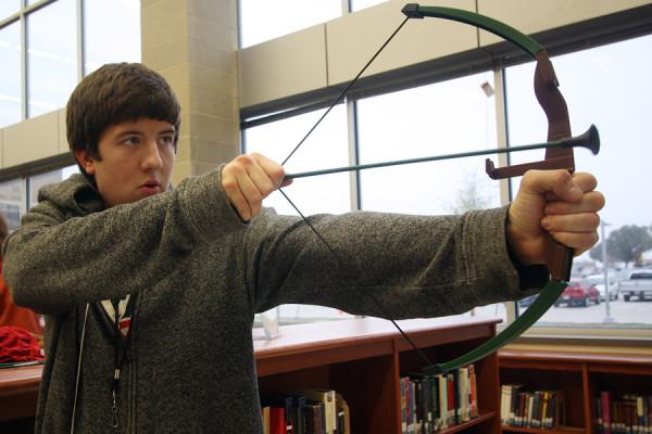 Senior+Randall+Sloan+focuses+on+his+next+shot+at+hitting+the+target+in+the+librarys+very+own+Hunger+Games.