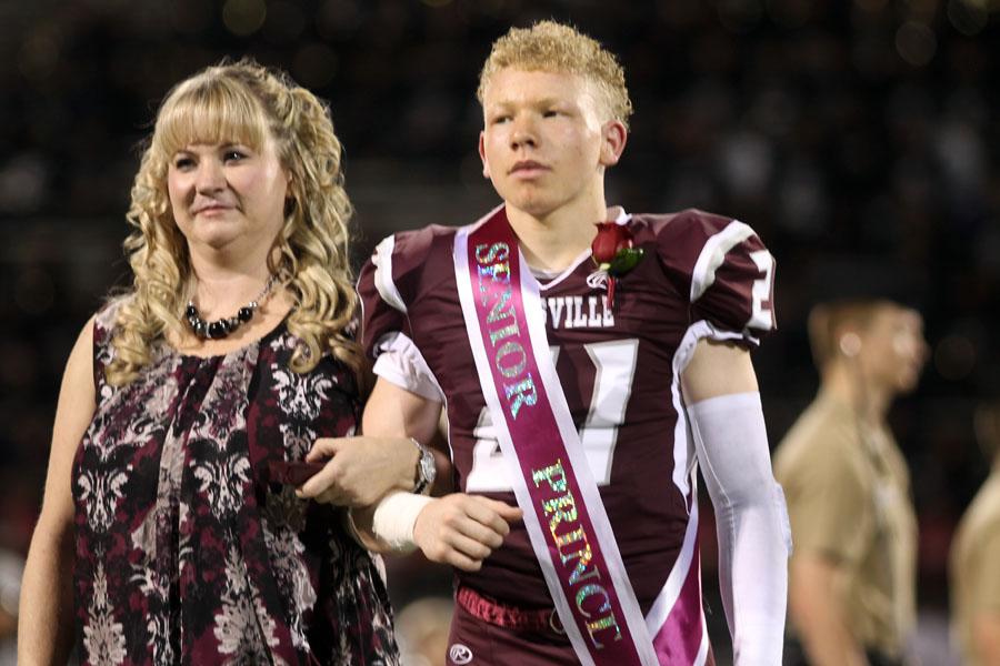 Senior Cori Williams walks across the field with his mom on his side.