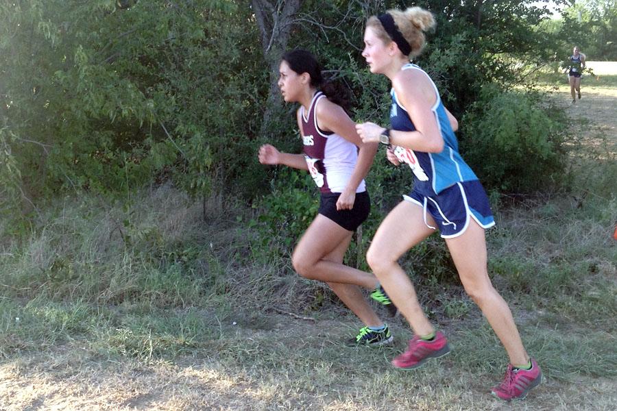 Junior Stephanie Figueroa (left) passes another runner during the Flower Mound Invitational on Sept. 6. 