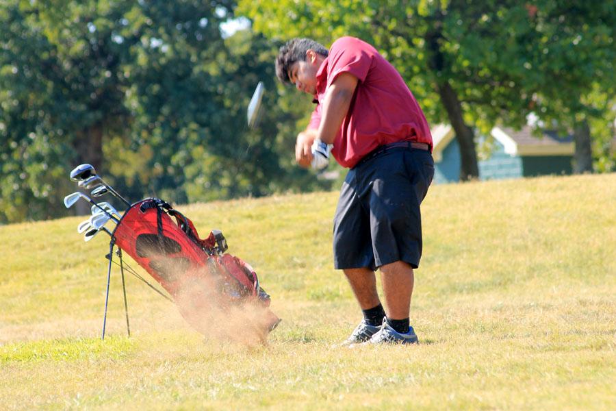 Senior Daniel Torres takes a swing at the golf ball.