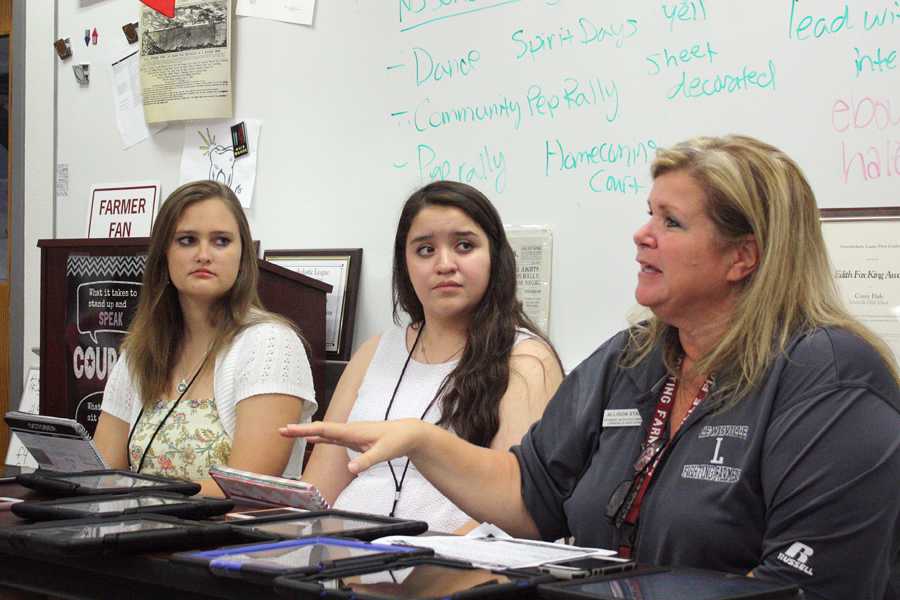 Senior StuCo officers Holly Weston (left) and Araceli Castillo (center) listen as adviser Allison Stamey talks about the Homecoming festivities during a journalism class press conference.