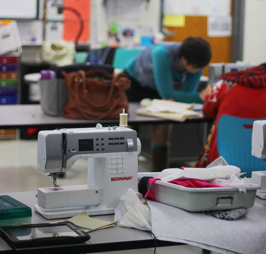 The teacher, students in the fashion design making handbags.