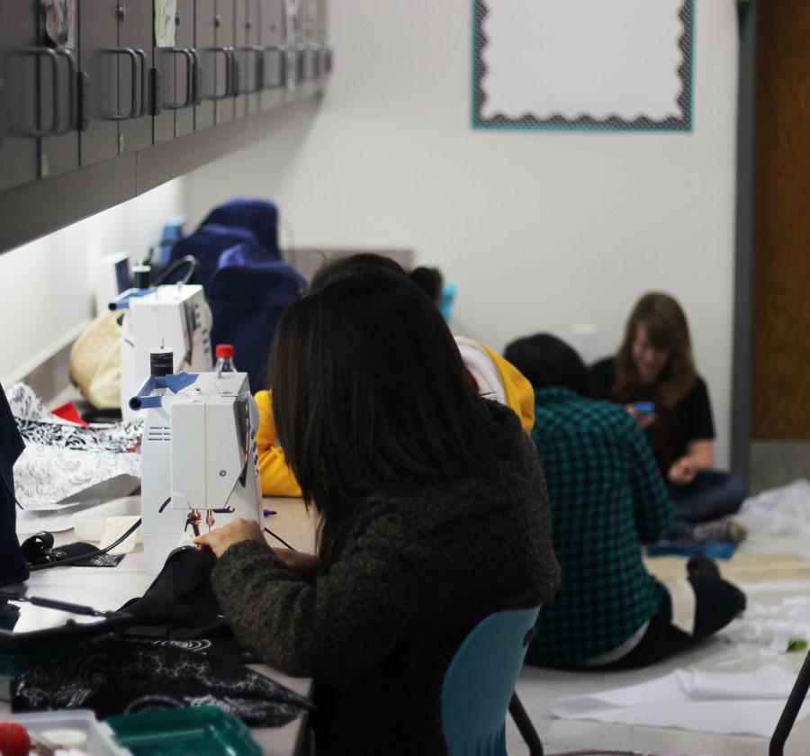 Students in the fashion design making handbags.