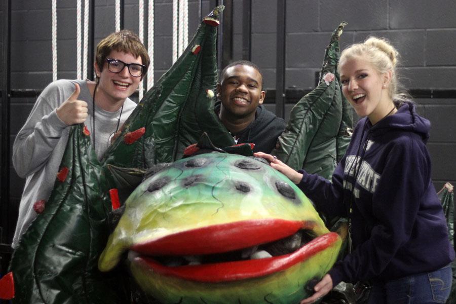 Senior Philip Robinson, junior Jenna Boyd and freshman Nate Courtney pose around Audrey II, the plant from Little Shop of Horrors.