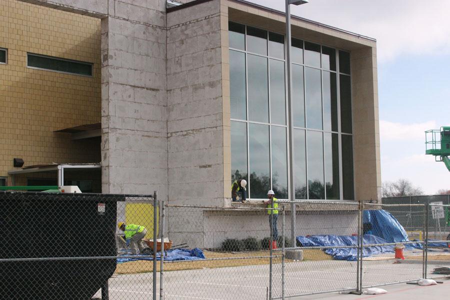 A construction crew works to strip and replace exterior  tiles on the science wing. The repair project is expected to take two weeks.