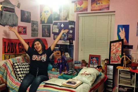 Jackie Guerrero sits on her bed surrounded by some of her concert merchandise, autographs and posters.