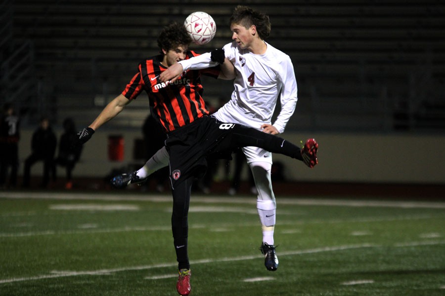 Junior John Cronin jumps for a header while his opponent challenges him for the ball.