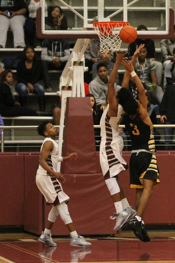 Senior Caleb Loggins attempts to get the ball from going in the basket on Feb. 3.