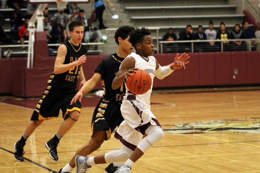 Senior Marquis Williams attempts to get the ball to the other side on feb. 3 at the game against Plano West.