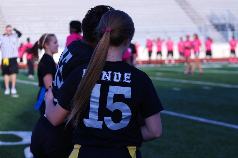 Senior girls stand together versus the Junior girls at the April 20 Powderpuff game .