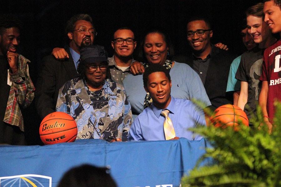 Basketball player Caleb Loggins signs to LeTourneau University as he is surrounded by family and friends.