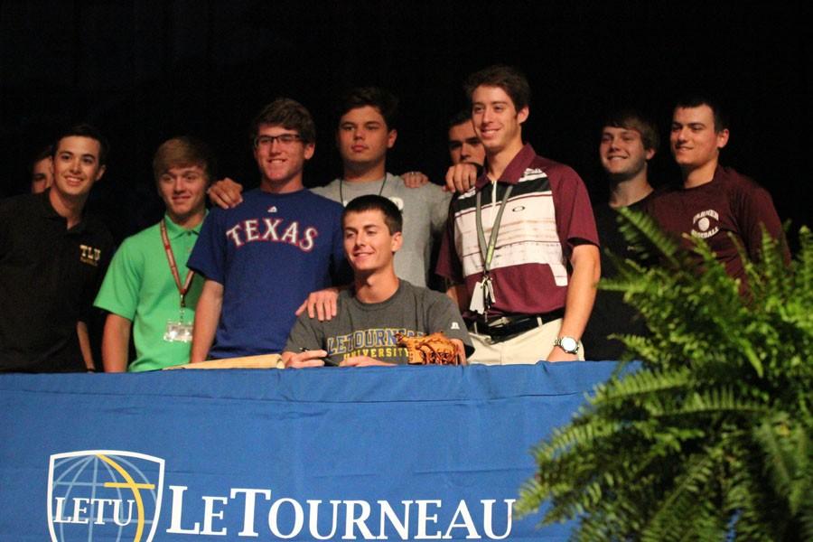 Baseball player Andrew Harlan poses for a picture with friends after signing to LeTourneau University.