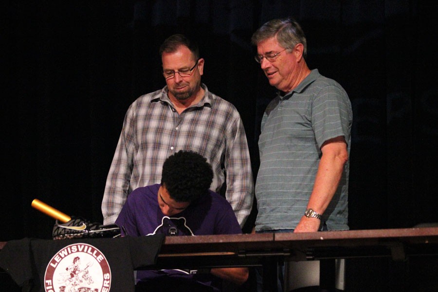 Justin Bubak signs to Central Arkansas University as family members look on.