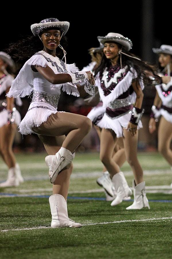 The captain of Farmerettes, senior Jessica Brown, smiles while she performs at halftime.
