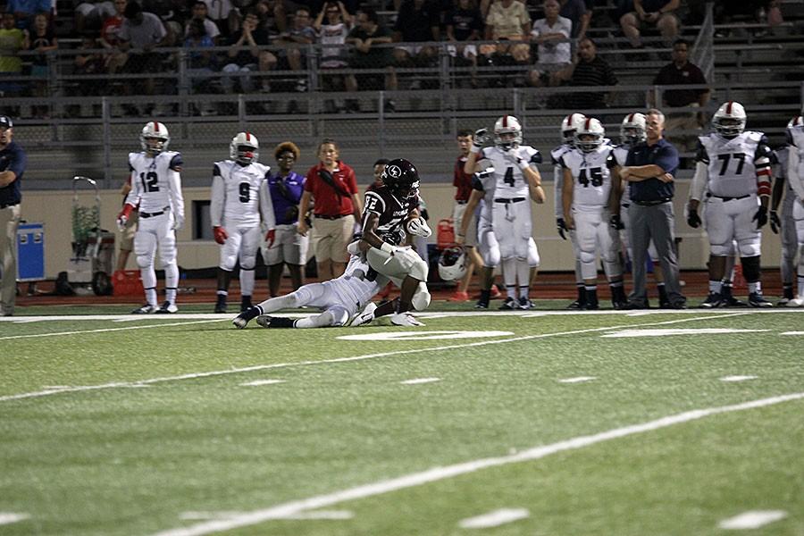 Senior Robert Benson (82) runs and gains the yards for the Farmers when a defensive Rebel stops him.