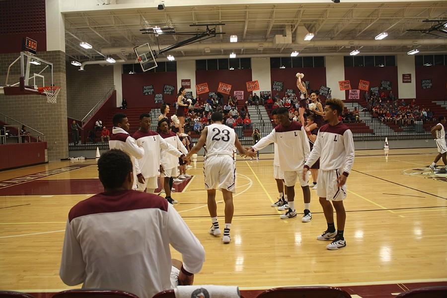 Before the Lewisville vs. Marcus game starts the juniors on the team line up as the seniors run down between them high-fiving. Senior, Jeremiah Taylor, 23 is first up.