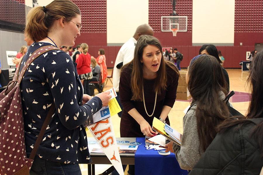 The representative from Oklahoma City University speaks to a student about her campus.
