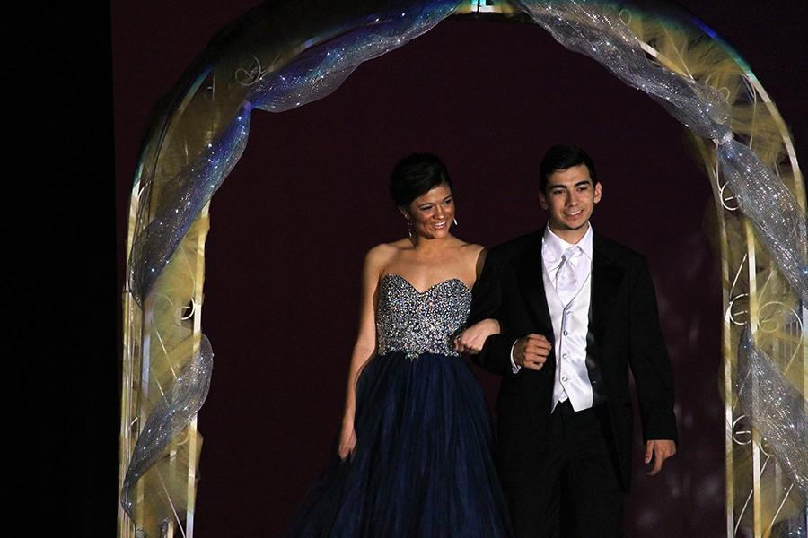 Senior Jessica Sims and junior Fabian Gutierrez smile at the audience as they walk out from backstage.