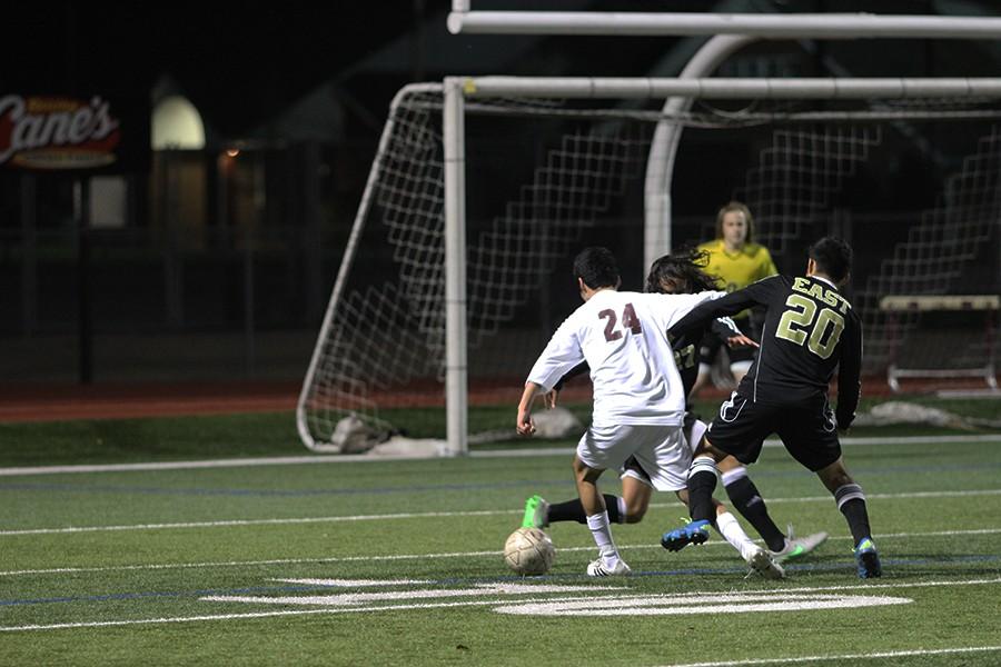 Christian Hernandez, #24, dribbles past two Plano East team mates on his way to the goal on the night of March 14. 