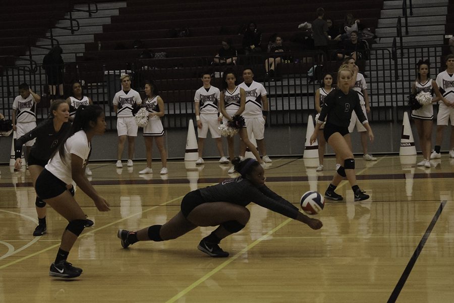 Senior Jayda Gibson (11) dives to pass the ball before it hits the ground.  
