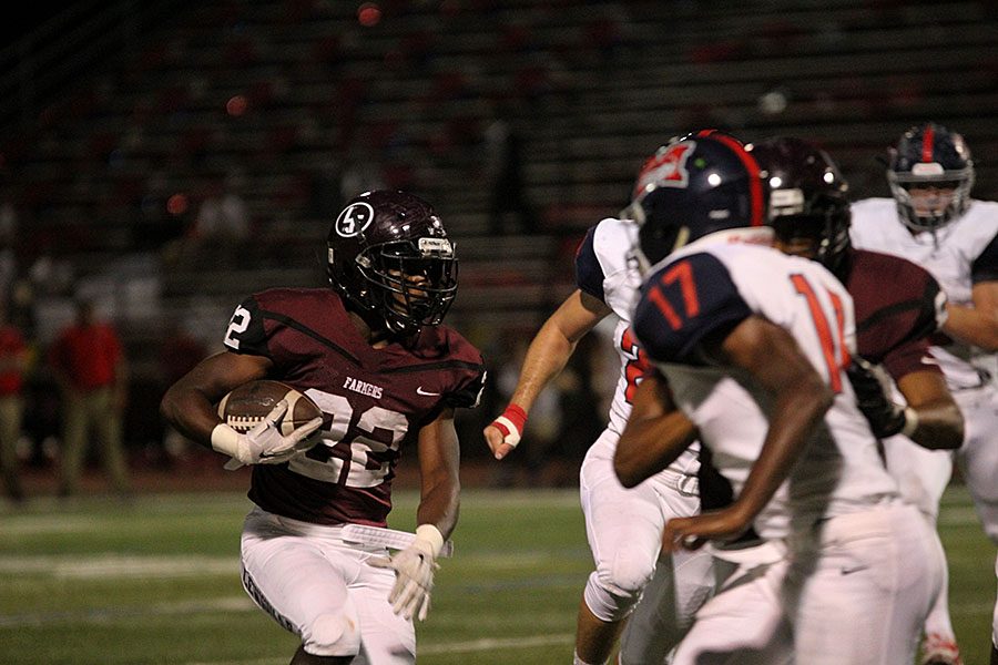 Senior Kwame Mickels (22) attempts to rush past the defenders during the Sept. 9 game against McKinney Boyd.