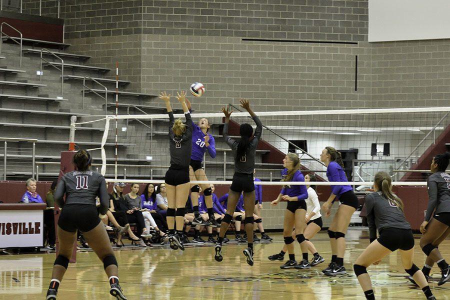 Junior Meredith Wagley (9) and Sophomore Isis Williams (17) jump to block an incoming spike from a Hebron player.
