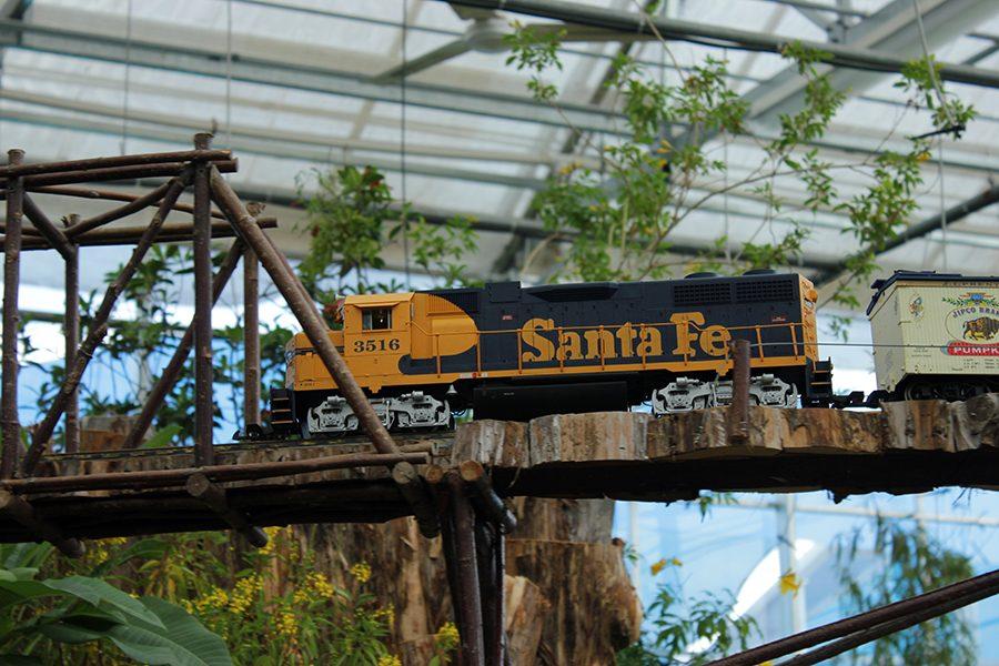 Miniature trains ride along the Texas Gardens Railway inside the Errol McKoy Greenhouse on the Midway.