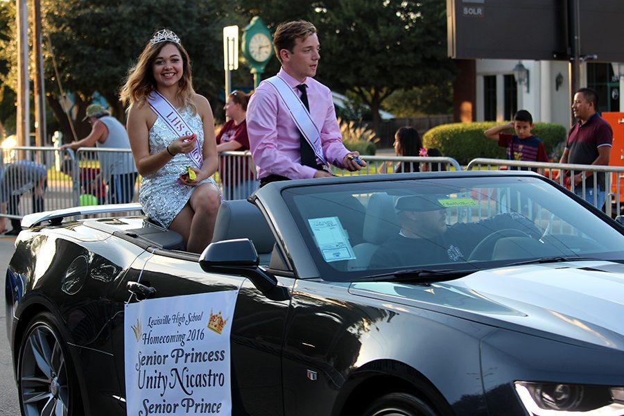 Senior princess Unity Nicastro and prince Brandon Barrows throw candy at the crowd on the sides of the parade.