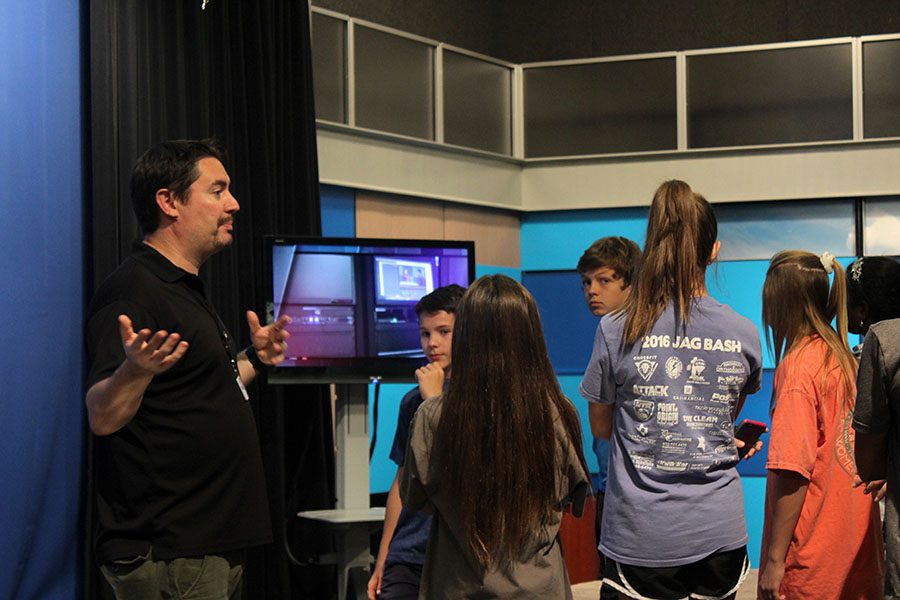 Mr. Brandon Jackson, who teaches AV Production, gives a tour to a middle school class. 