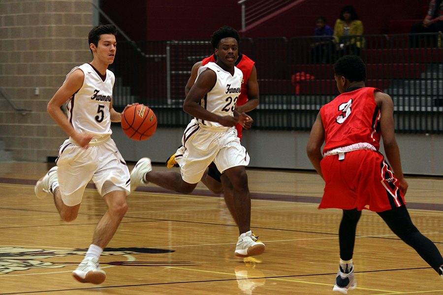 After getting the rebound, junior Ethan Gregory (5) runs the ball down the court. 