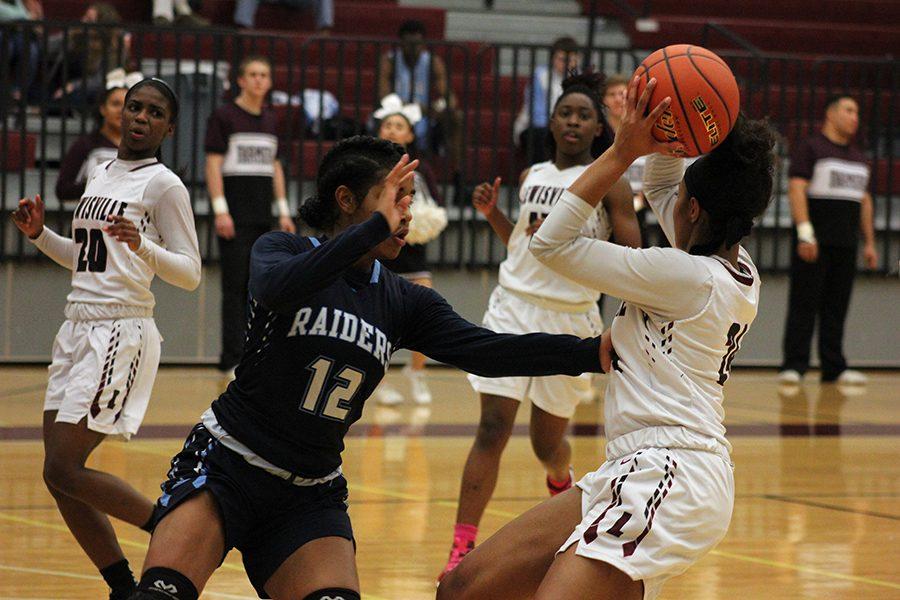 Junior McKenzie Bowie (24) looks to pass the ball to senior Sharmaine Harper (20) or sophomore Nala Hemingway (15) during the L.D. Bell game on Friday, Feb. 3.