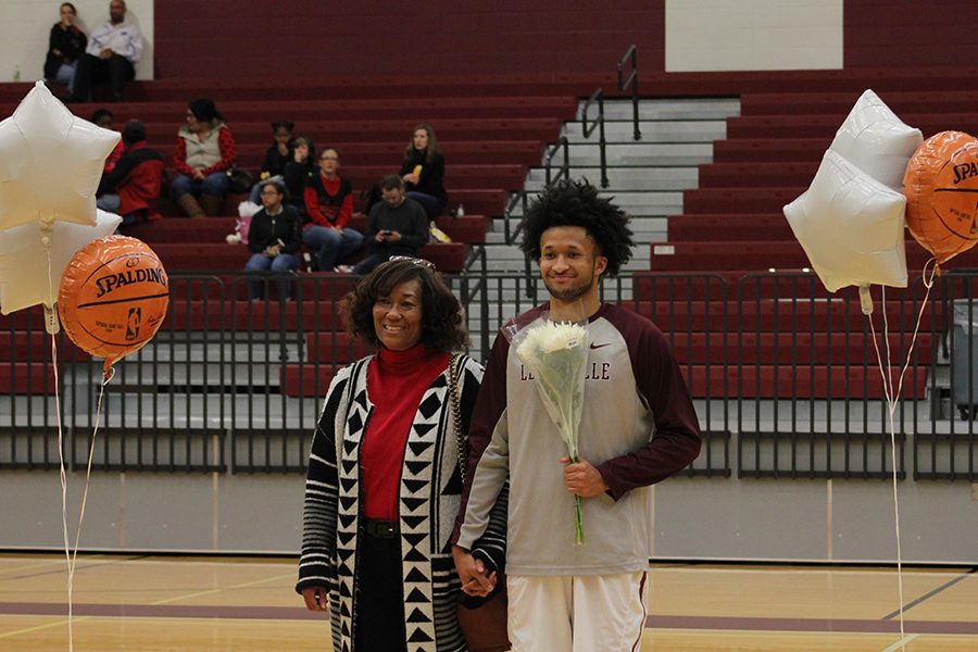 Senior Jajuan Nash and his mother hold hands and smile for a picture.
