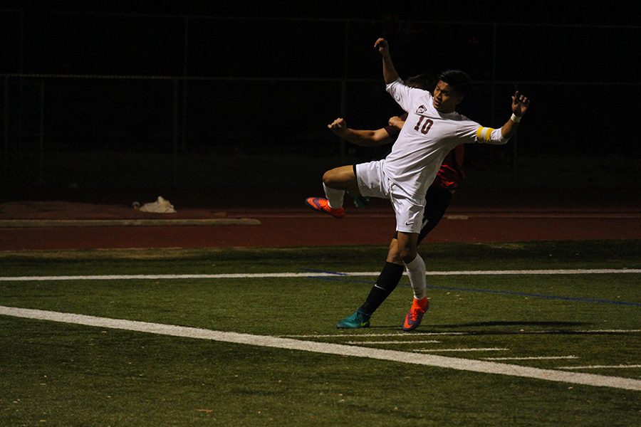 Senior Peter Hmung (10) attempts to block the defenders clearance.