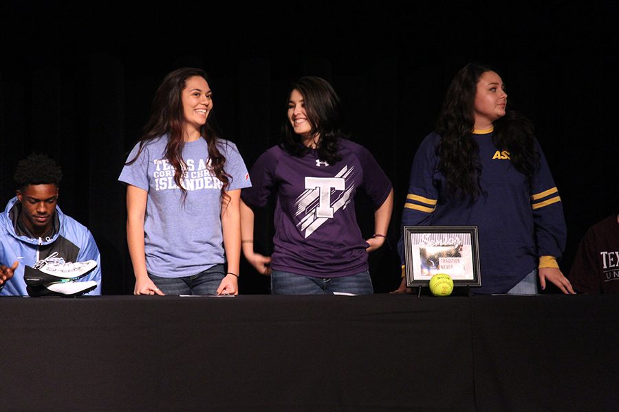 Katrina Jackson, Kaylee Rodriquez and Makayla Corbin stand on stage as their softball coach introduces them.