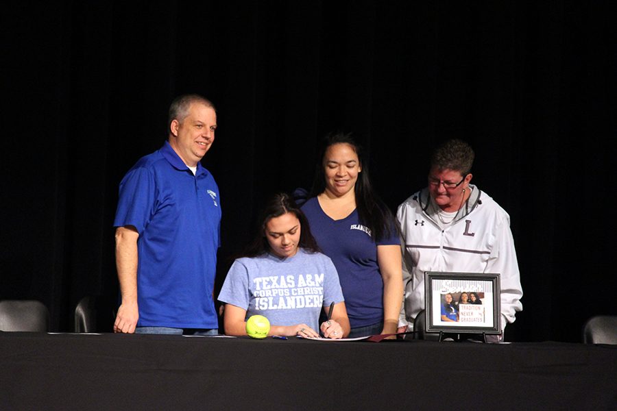 Katrina Jackson signs to Texas A&M Corpus Christi for softball with her family and coach beside her.