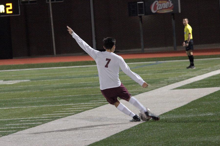 Senior Julio Gomez, 7, takes a free kick at the goal.