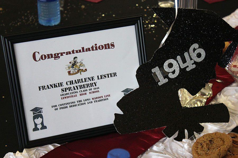 Tables in the auditorium lobby feature various decorations including cutout and framed award centerpieces congratulating Frankie Sprabary.