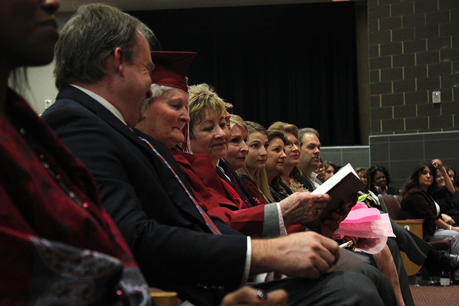 Frankie Sprabary admires her diploma with her son and other family members sitting next to her.