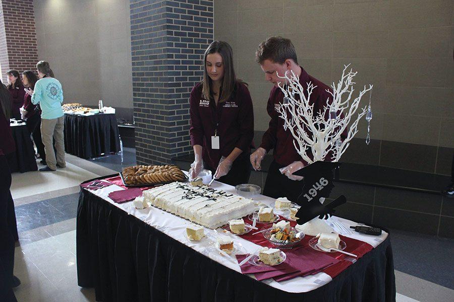 Senior Student Council officers Tori King and Patrick Devaney cut cake after the graduation ceremony.