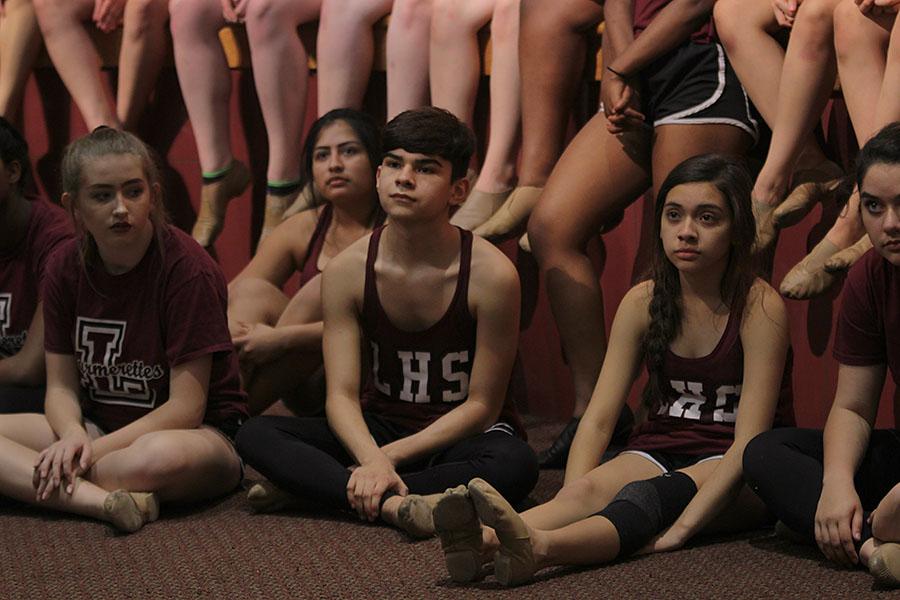 Junior George JJ Martinez sits with the rest of the Diamonds as the coach instructs them about the routine. 