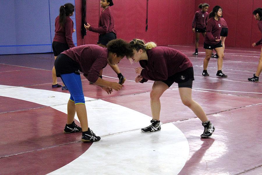 Freshman Aaleya Gay and junior Lydianna Hill prepare to go head to head during practice.  
