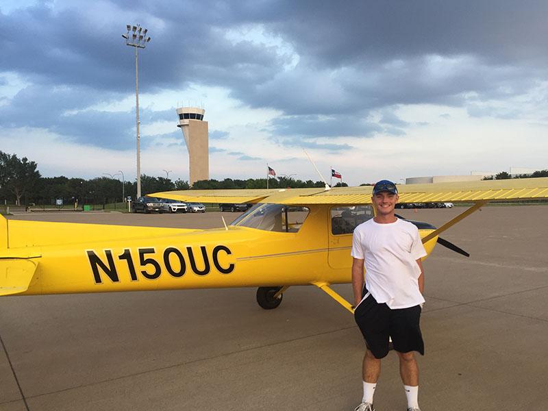 Senior Carder Gregory stands next to a biplane. Courtesy of Carder Gregory.