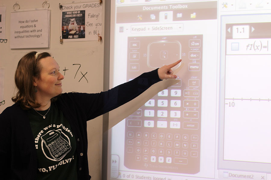 Algebra teacher Leigh Ann Mitchell assists students in solving an equation.