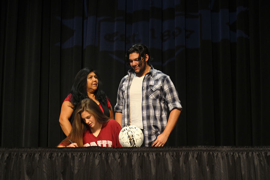 Senior Emily Palmore commits to play soccer at Southern Nazarene University, with her mother and brother alongside her.