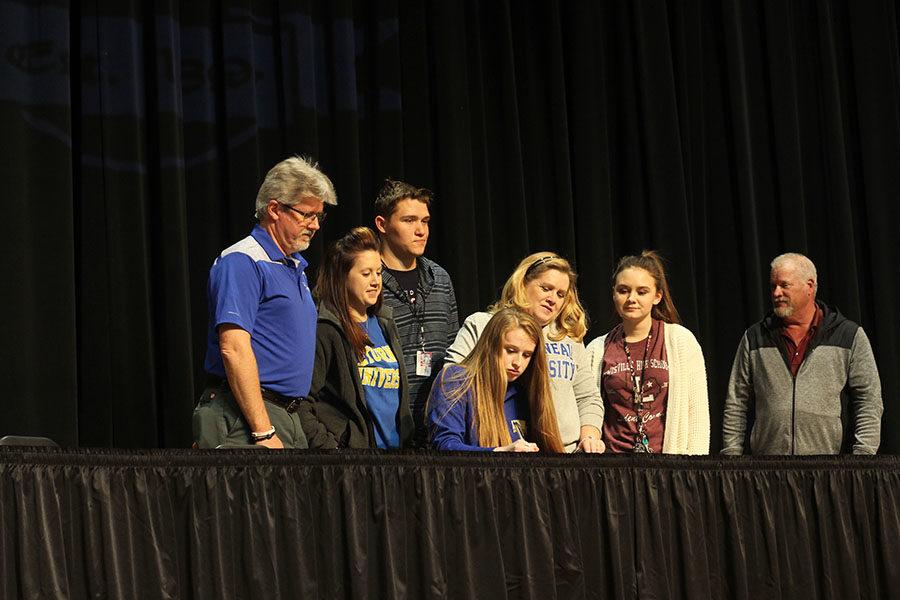Kayley Packer signs with LeTourneau University for pole vaulting, while surrounded by her family, friends and coach