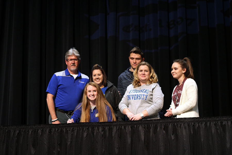Senior Kaylee Packer looks up from her contract to LeTourneau University for pole vaulting. 