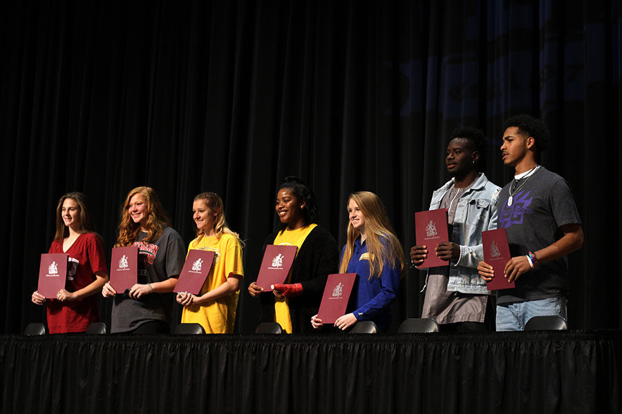 All seven National Signing Day honorees display their signed contracts on Wednesday, Feb. 7.