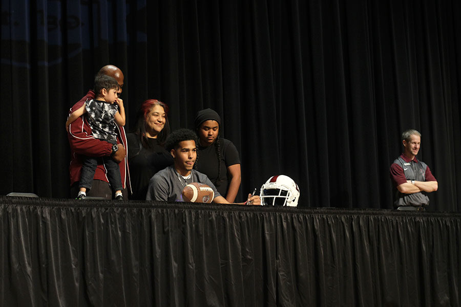 Senior Woody Banks signs to play football at Southwestern College, accompanied by his family.