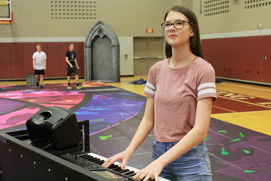 Senior Krista Anderson looks at the assistant director while playing keyboard during drumline practice.