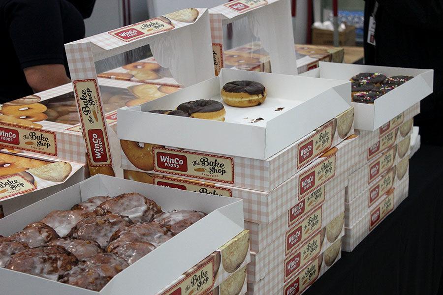 A collection of various donut boxes sits open on a table for the attendees.